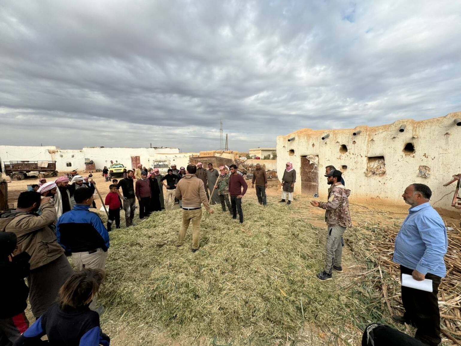 Landwirte*Landwirtinnen versammeln sich vor Ibrahims Haus zur Farm Field School. Landwirte*Landwirtinnen versammeln sich vor Ibrahims Haus zur Farm Field School.