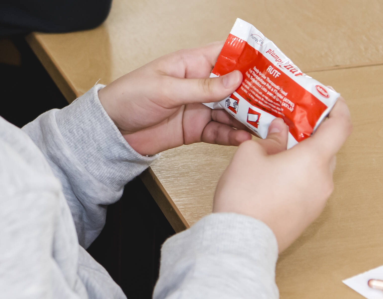 Schüler*innen lernen im Unterricht Plumpy’Nut als Hilfsmittel zur Behandlung von Mangelernährung kennen.