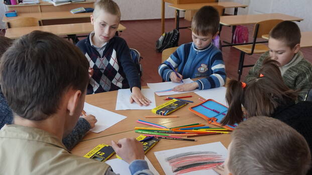 Mitarbeiter von Aktion gegen den Hunger mit Schulkindern in der Ukraine.