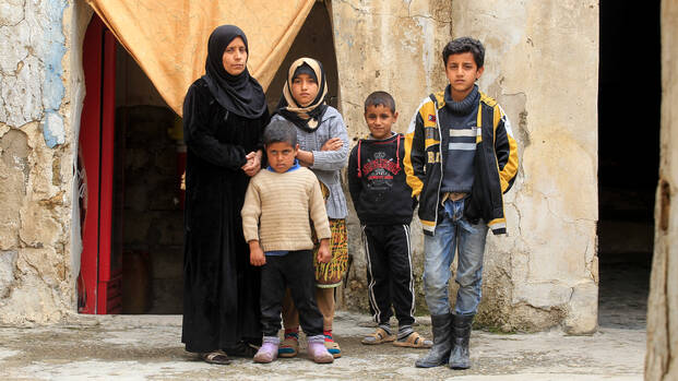 Familie im Irak steht vor ihrer Wohnung.