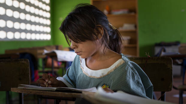 Mädchen in Kolumbien sitzt im Klassenraum.