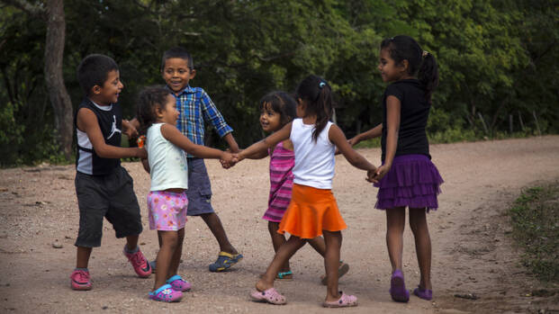 Kinder in Nicaragua tanzen im Kreis.