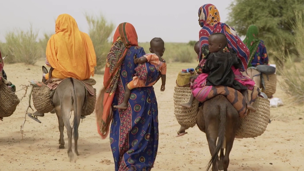 Frauen im Tschad laufen durch den Sand.
