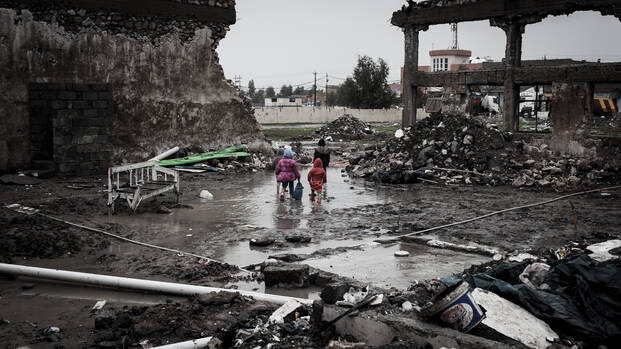 Kinder laufen durch vom Krieg zerstörte Stadt.