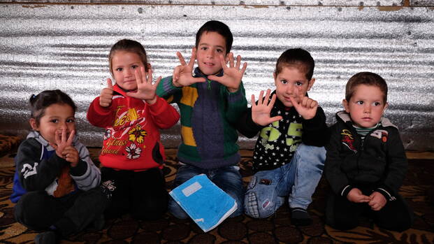 Syrische Flüchtlingskinder zeigen wie alt sie sind.