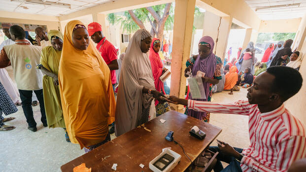 Mitarbeiter von Aktion gegen den Hunger verteilt Geld an Menschen in Nigeria.