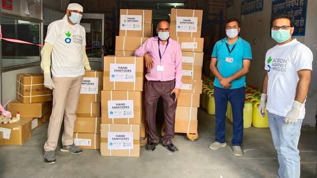 Mitarbeiter von Aktion gegen den Hunger verteilen Hygiene-Kits.