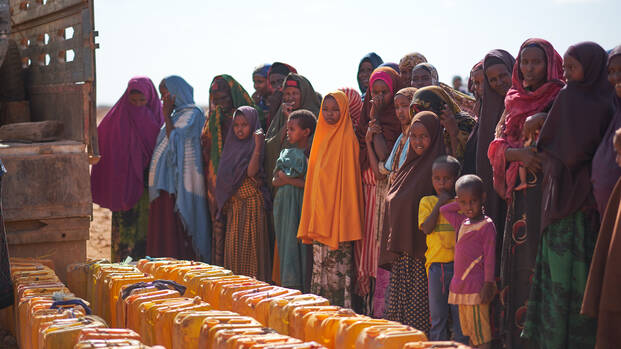 Menschen in Somalia warten mit ihren Kanistern auf sauberes Wasser aus Wassertank.