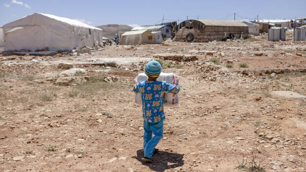 Junge im Flüchtlingslager trägt Windeln für seinen Bruder