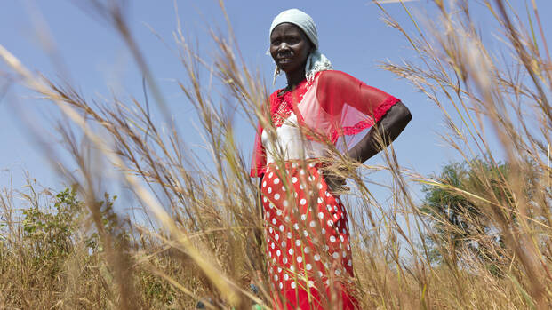 Frau steht im Feld im Südsudan