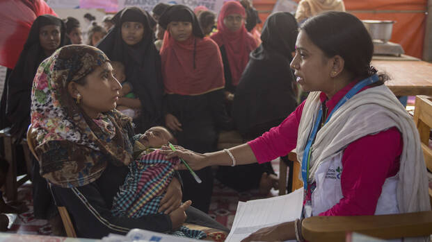 Mitarbeiterin von Aktion gegen den Hunger hilft Mutter und Kind in Bangladesch