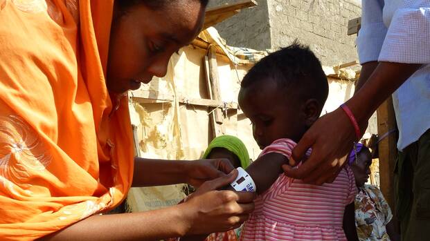 Mitarbeiterin von Aktion gegen den Hunger behandelt Kind in Dschibuti