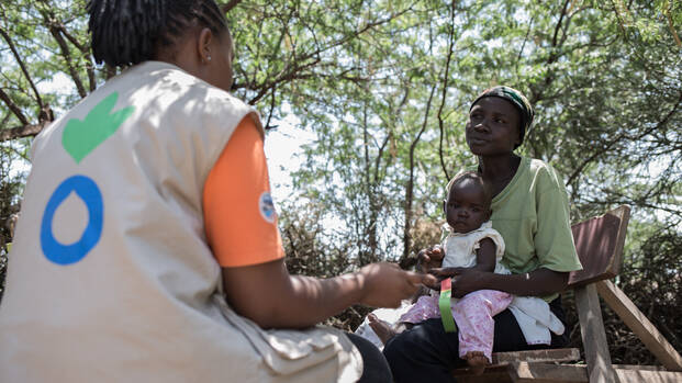 Mitarbeiterin von Aktion gegen den Hunger hilft Mutter und Kind in Kenia