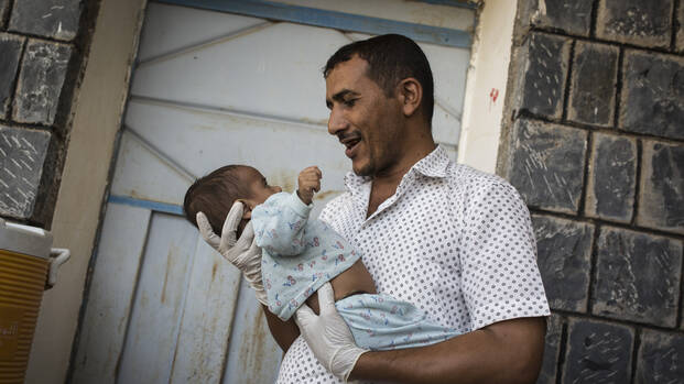 Krankenpfleger im Jemen hält Kind im Arm