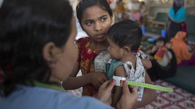 Mitarbeiterin von Aktion gegen den Hunger misst Kind mit dem MUAC-Band in Bangladesch