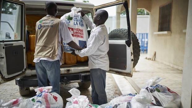 Mitarbeitenden von Aktion gegen den Hunger packen Hilfspakete ins Auto