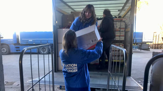 Mitarbeiterinnen von Aktion gegen den Hunger beladen Transporter