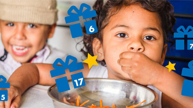 Kinder essen mit den Händen und Adventskalender-Geschenke