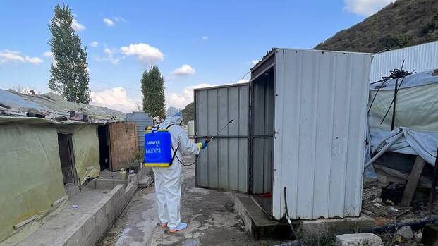 Ein*e Mitarbeiter*in desinfiziert eine Toilette in einem GeflÃ¼chtetenlager im Libanon.