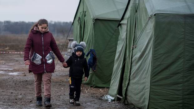 Eine Mutter geht mit ihrem Sohn durch ein Aufnahmelager an der ukrainisch-moldawischen Grenze.