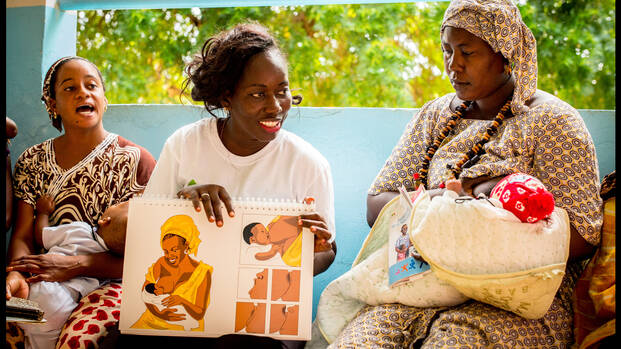 Stillberatung von Aktion gegen den Hunger: Eine Mitarbeiterin zeigt stillenden Müttern, wie sie ihre Babys am besten mit Muttermilch versorgen.