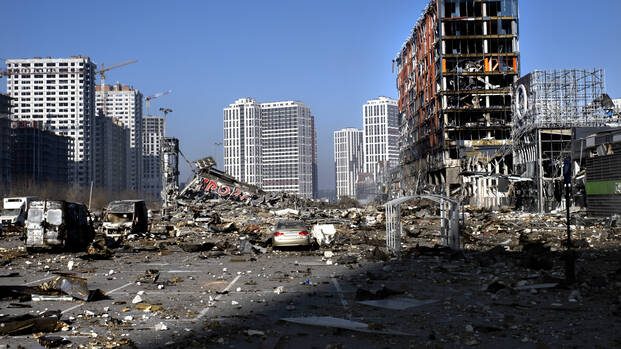 Ruinen und ein Parkplatz voller Geröll, im Hintergrund Hochhäuser – hier stand bis März 2022 eine Shopping Mall in Kiyv.