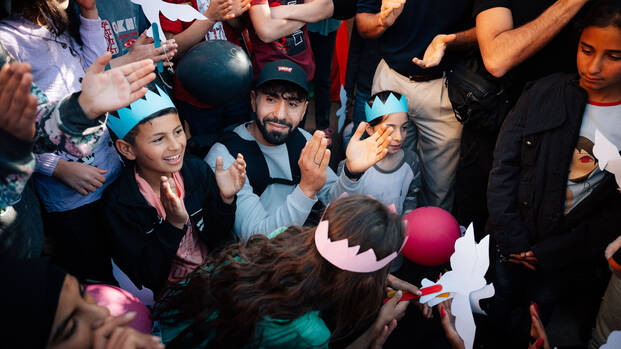 Kinder aus dem Libanon mit Papierkronen und Friedenstauben, zusammen mit Rapper Motrip