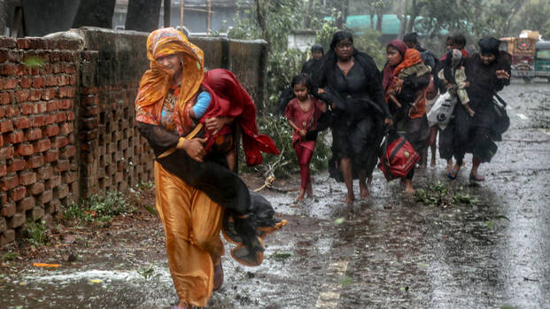 Frauen mit Kindern flÃ¼chten durch den Regen vor Zyklon Mocha in Bangladesch