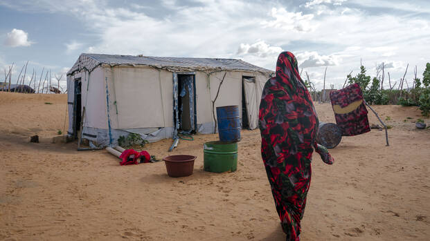 Eine Frau im Flüchtlingscamp Mbera in Mauretanien auf dem Weg zu ihrer Unterkunft.
