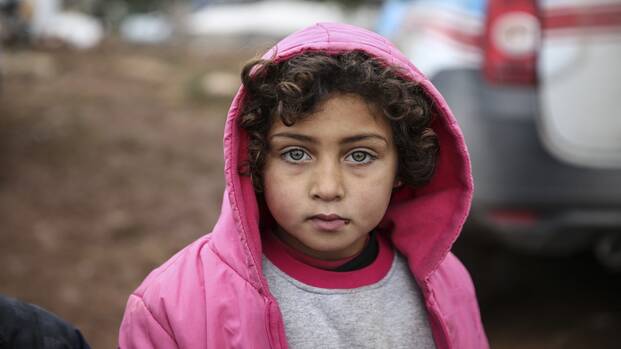 Frauen aus Kenia schlagen freudig ein, eine strahlt dabei in die Kamera.