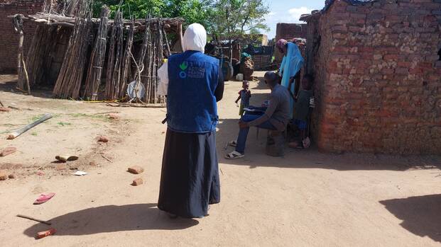 Eine Mitarbeiterin von Aktion gegen den Hunger läuft durch ein sudanesisches Dorf.