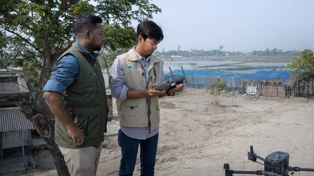 Zwei Mitarbeiter von Aktion gegen den Hunger beim Bedienen einer Drohne in Bangladesch.