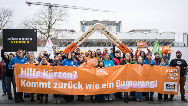 16 Hilfsorganisationen demonstrieren mit Riesenbumerang vor dem Paul-Löbe-Haus in Berlin und fordern Kurskorrektur für den Bundeshaushalt