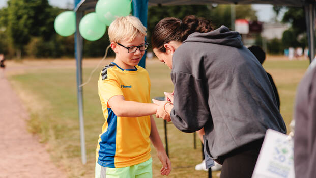 Schüler erhält vor dem Lauf sein Teilnahme-Armband Schüler erhält vor dem Lauf sein Teilnahme-Armband