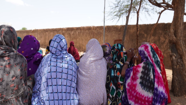 Frauen kommen in einer Selbsthilfegruppe zusammen. Rückansicht einer Gruppe von Frauen, die auf dem Boden sitzt.