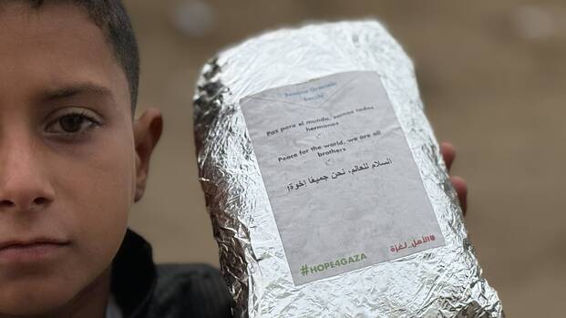 Hope4Gaza: Junge hält Lebensmittelpaket mit Botschaft der Hoffnung in der Hand