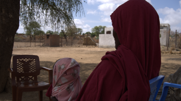 Eine Frau und ihr Kind seitlich/von hinten fotografiert im Sudan