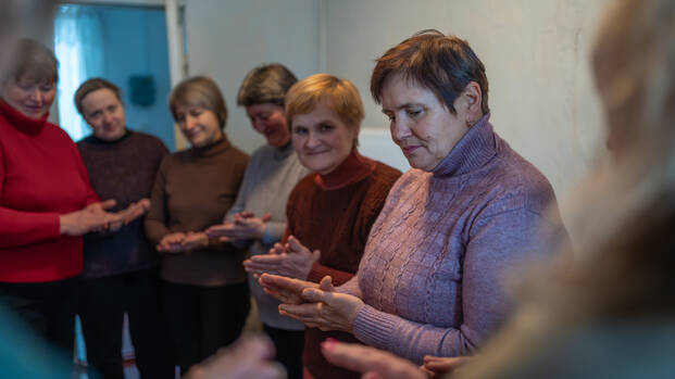 Stehende Frauengruppe bei einer psychologischen Gruppensitzung von Aktion gegen den Hunger in der Klinik von Kurmany, Region Sumy