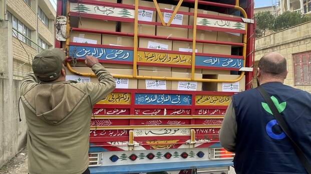 Mitarbeitende von Aktion gegen den Hunger entladen Hilfspakete im Libanon