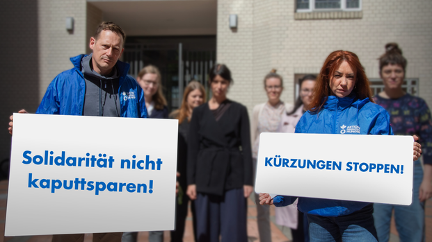 Menschengruppe hält Schilder hoch