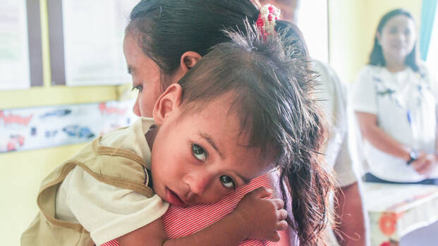Indonesien: Mutter hat ihr Kind auf dem Arm.
