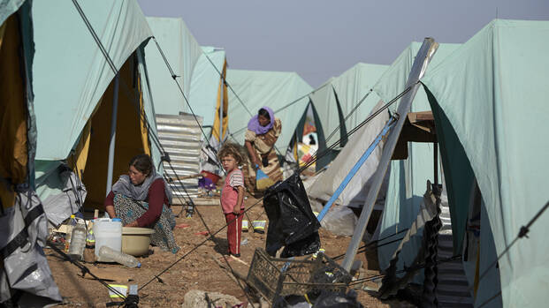 Kind steht inmitten von Zelten eines FlÃ¼chtlingslagers.