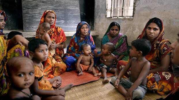 Eine Gruppe Menschen in Bangladesch sitzt zusammen im Haus.