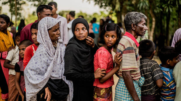 Menschen stehen in Bangladesch für etwas zu Essen in einer Reihe an.