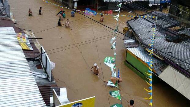 Menschen in Mindanao kämpfen gegen die Wassermassen, verursacht durch den Taifun Tembin.
