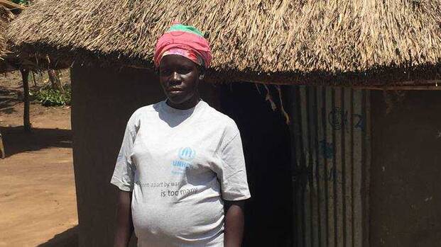 Roda steht vor ihrem Haus in Uganda.