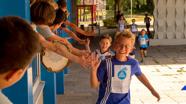 Schüler beim Lauf gegen den Hunger klatschen bei ihren Mitschülern ab.